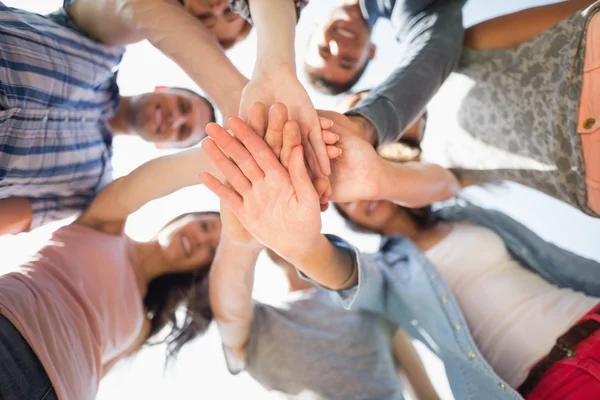 Happy students putting their hands together