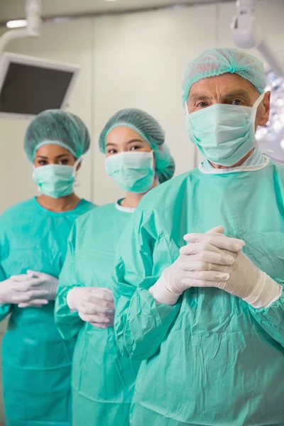 Medical student and lecturer looking at camera in scrubs