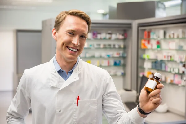 Handsome pharmacist holding medicine jar