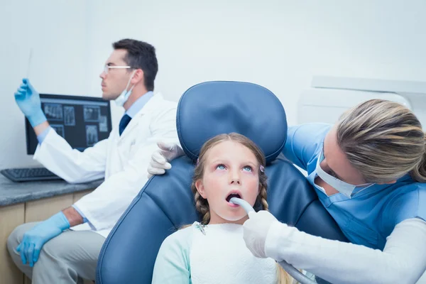 Female dentist examining girls teeth