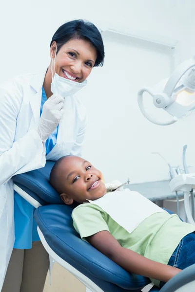 Portrait of smiling female dentist examining boys teeth