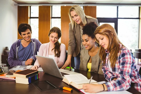 Professor teaching group of students in library