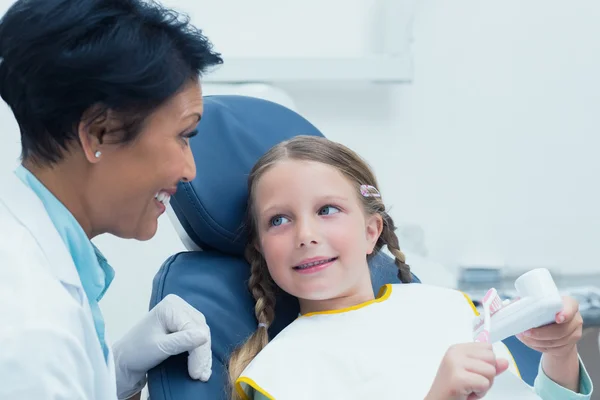 Dentist teaching girl how to brush teeth