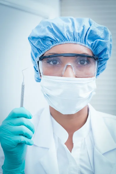 Female dentist wearing surgical mask and safety glasses