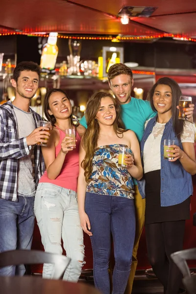 Smiling friends drinking beer and mixed drink