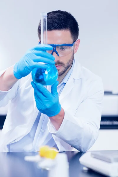 Science student looking at beaker