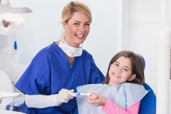 Dentist teaching to her young patient