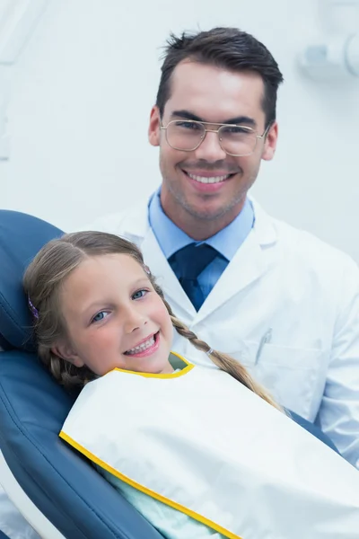 Male dentist examining girls teeth