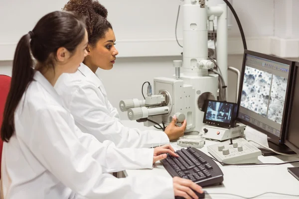 Science students looking at microscopic image on computer