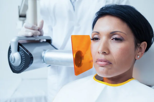 Serious young woman undergoing dental checkup