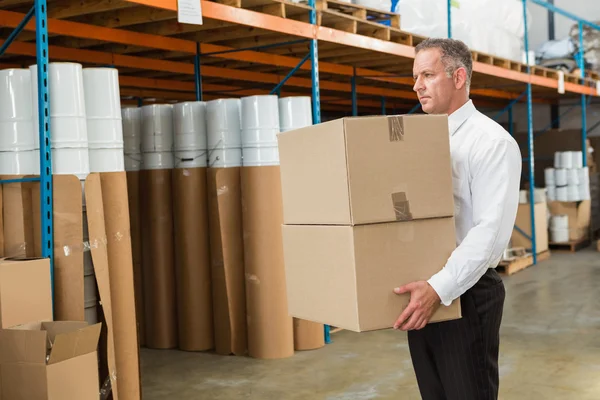 Warehouse manager carrying cardboard boxes