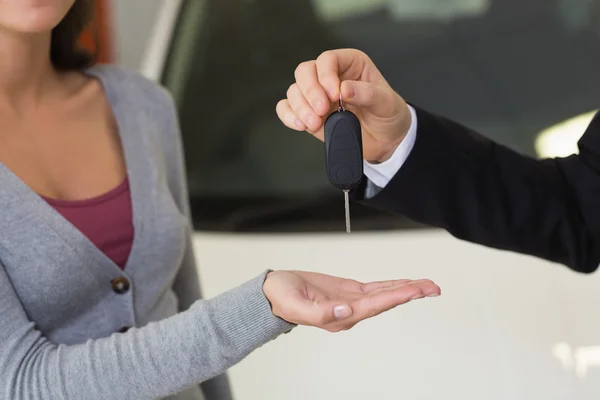 Businessman giving car key to customer