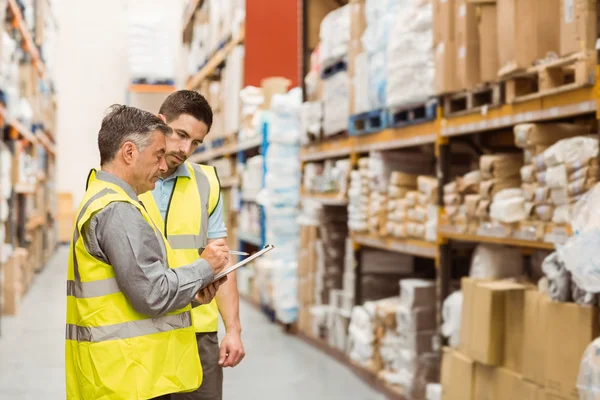 Warehouse workers talking together at work