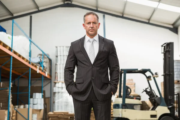 Manager with arms crossed in warehouse