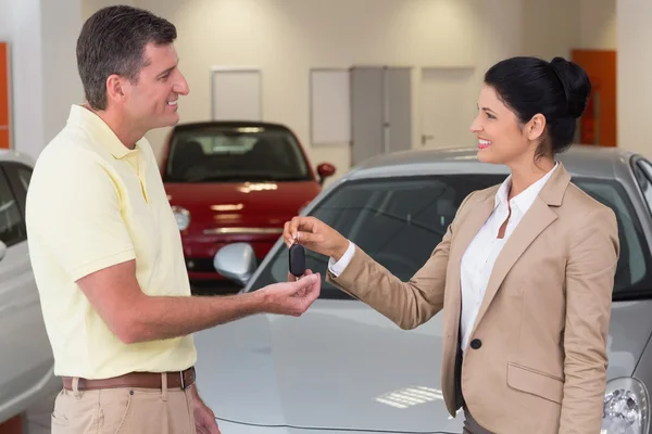 Businesswoman giving car key to customer