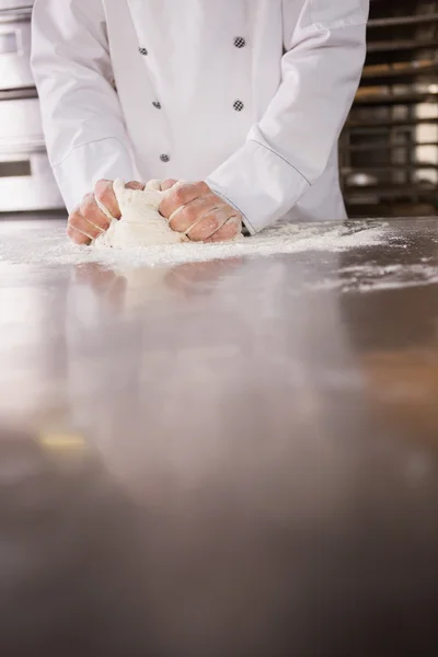 Baker kneading dough on counter