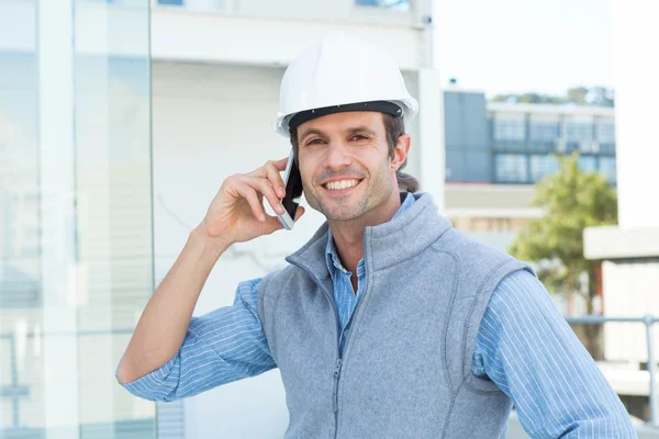 Smiling architect using mobile phone