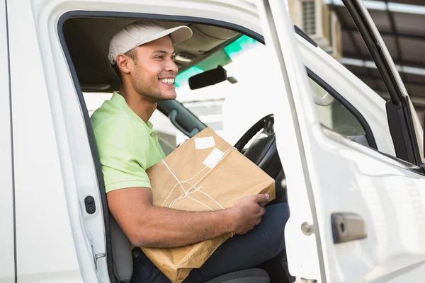 Delivery driver in his van holding parcel