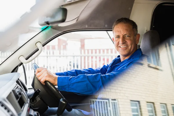 Smiling delivery man driving his van