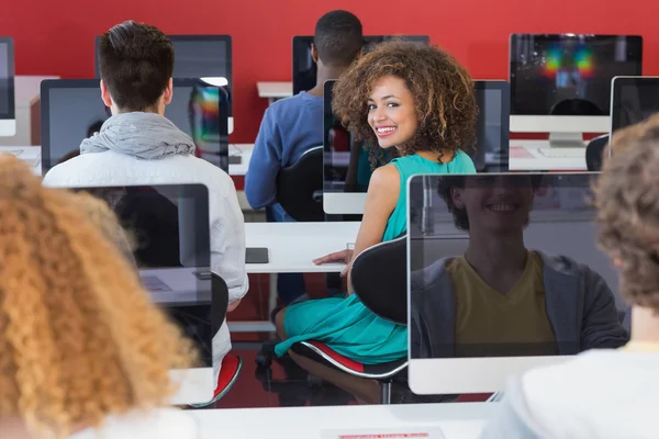 Student smiling at camera in computer class