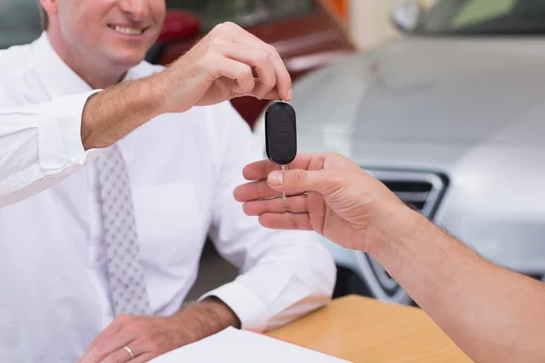 Salesman giving a customer car keys