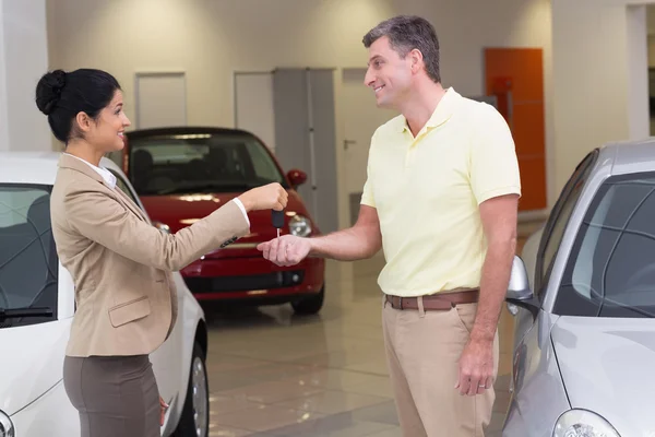 Businesswoman giving car key to customer