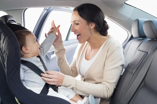 Mother securing her baby in the car seat