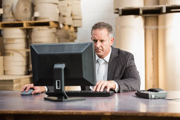 Warehouse manager working on computer