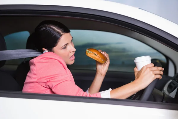 Woman drinking coffee and eating sandwich