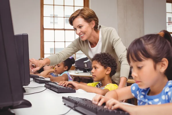 Cute pupils in computer class with teacher