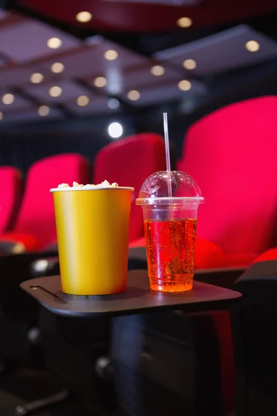 Empty rows of red seats with pop corn and drink on the floor