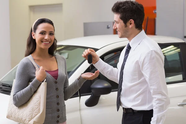 Businessman giving car key to customer