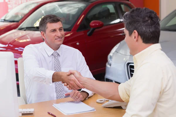 Smiling salesman shaking a customer hand