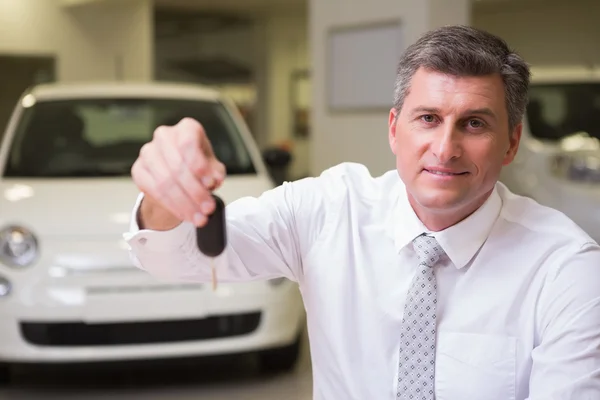 Smiling salesman giving a customer car keys