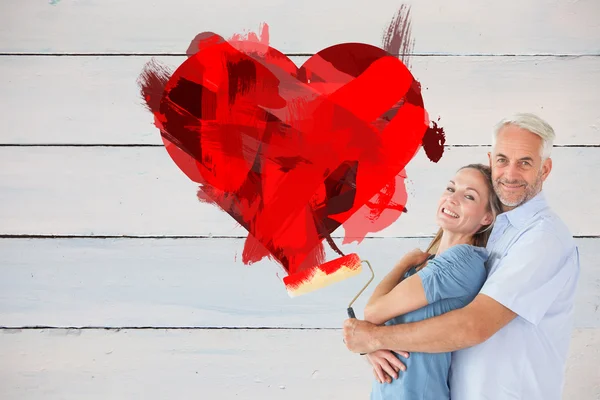 Couple hugging and holding paint roller