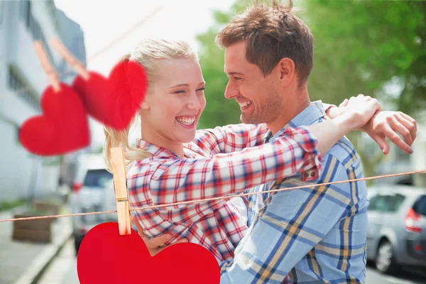 Couple in check shirts and denim hugging each other