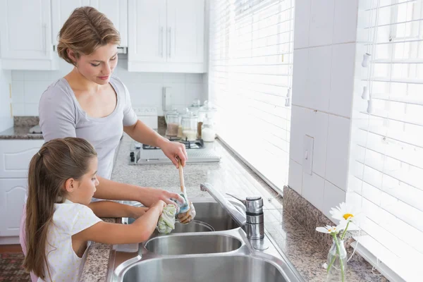 Mother and daughter washing up