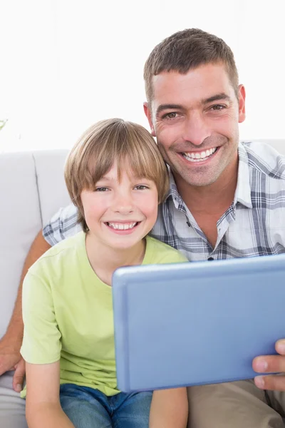 Happy father and son with digital tablet