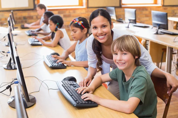 Cute pupils in computer class with teacher