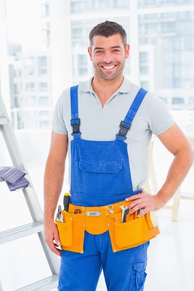 Handyman in overalls at modern office