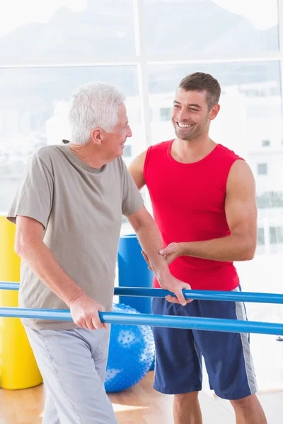 Senior man walking with coach help