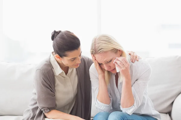Patient crying next to her therapist