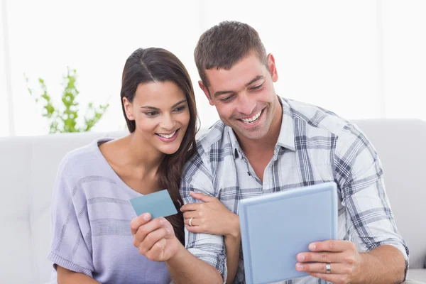 Couple shopping online on digital tablet using credit card