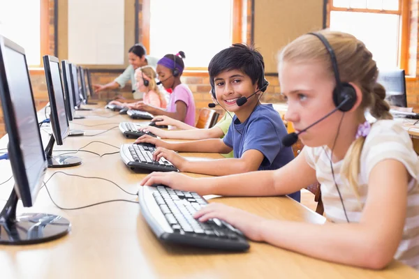 Cute pupils in computer class with teacher