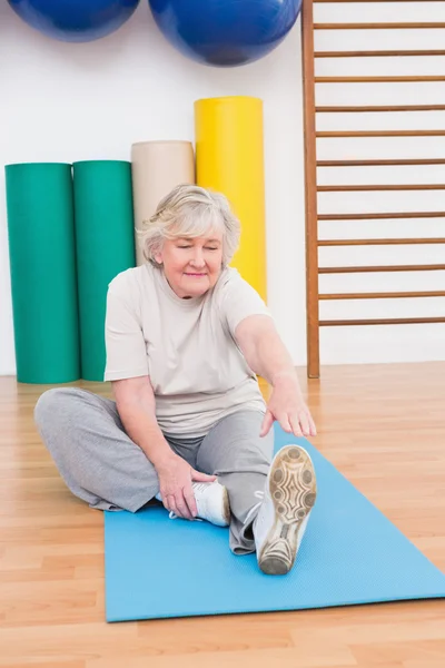 Senior woman working on exercise mat