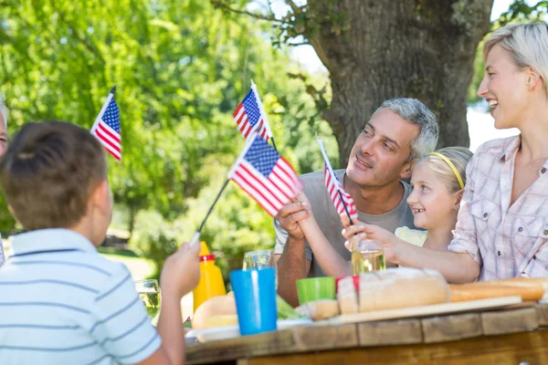 Family having picnic and holding american flag