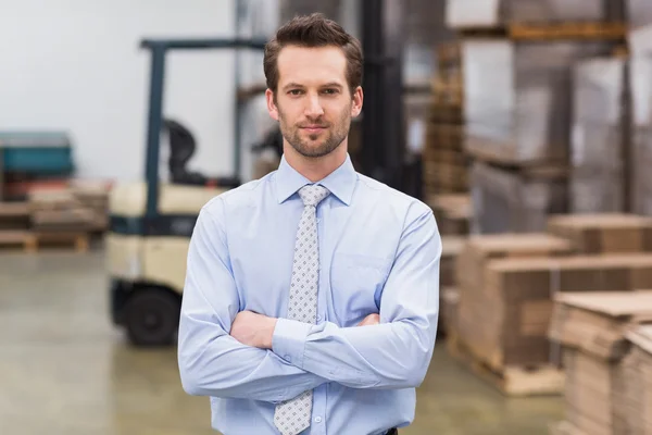 Manager with arms crossed in warehouse