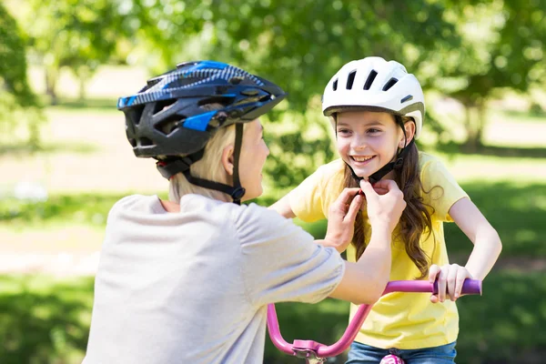 Mother attaching daughters cycling helmet