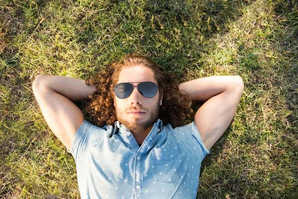 Young man lying down in park
