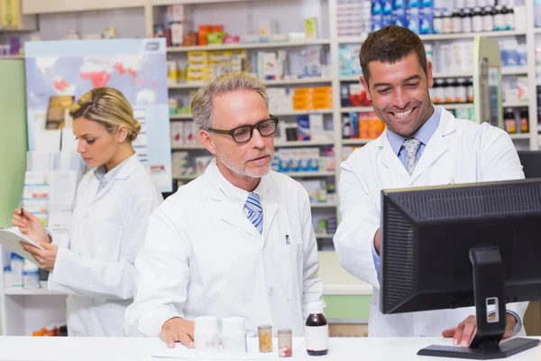 Team of pharmacists looking at computer